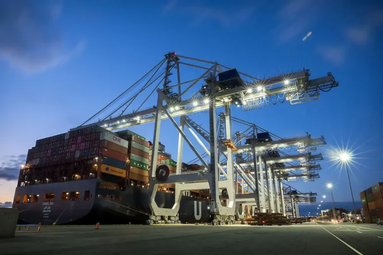Ship-to-shore container crane beside a vessel at a port berth