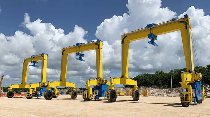 Compact yellow single-girder rubber-tired gantry cranes in an outdoor yard