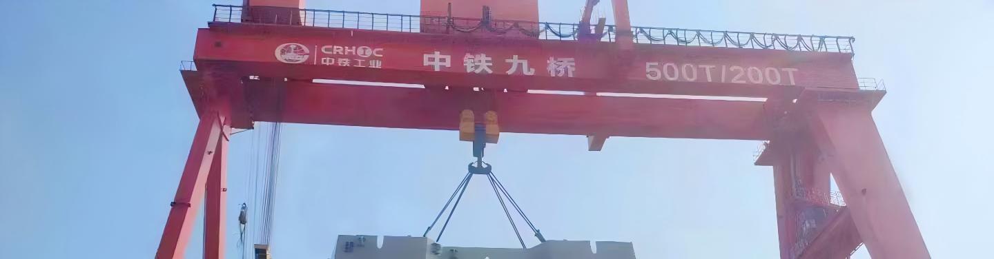 Heavy gantry crane lifting a bridge tower construction component