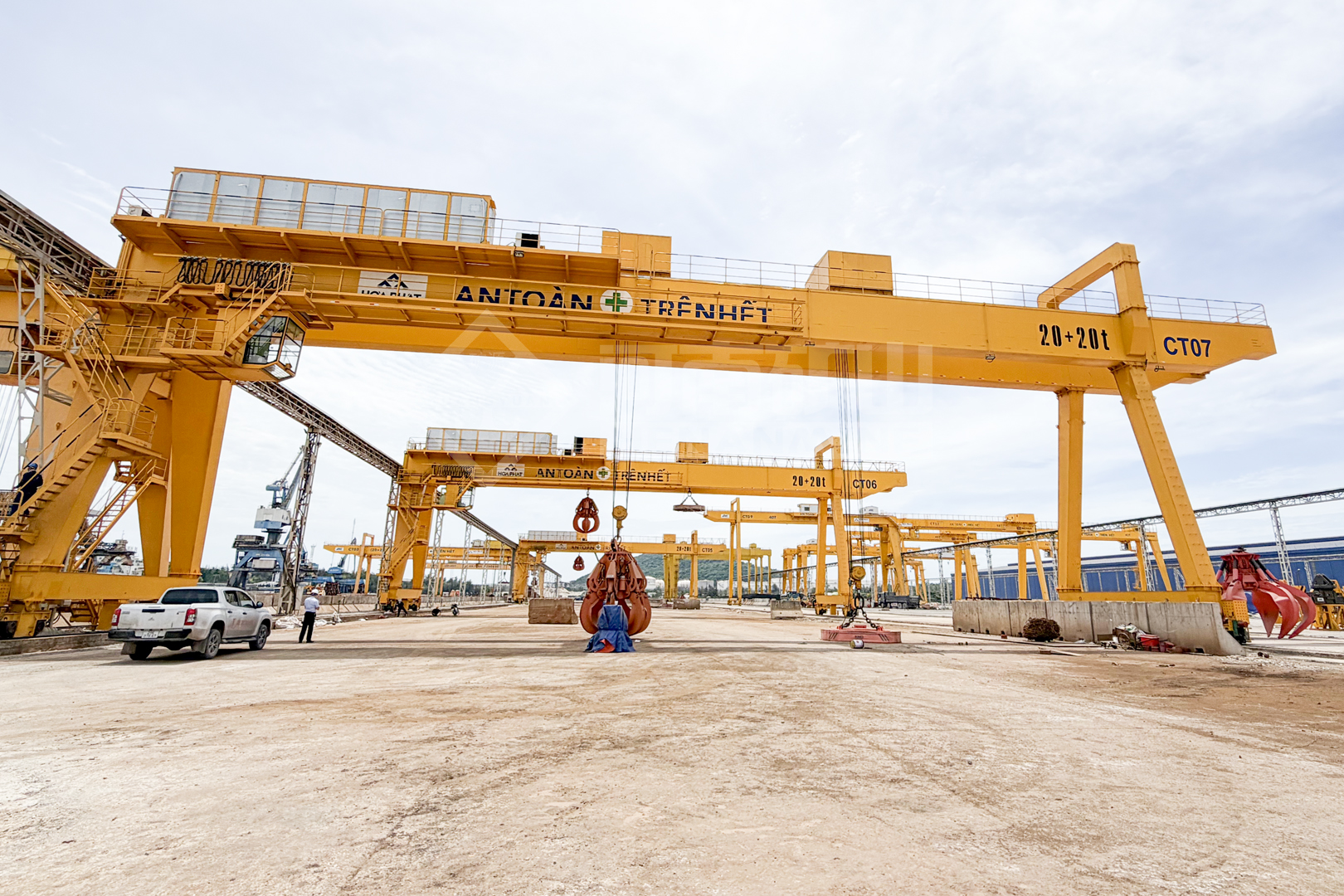 Rail-mounted double-girder gantry cranes with grabs at an outdoor steel-plant yard