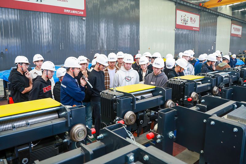 University Internship Connects Mechanical Engineering with Crane Production — image 2 University students receiving engineering instruction at the crane factory