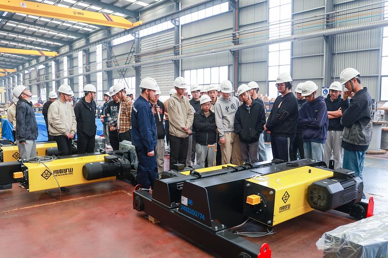 University Internship Connects Mechanical Engineering with Crane Production — image 3 University students receiving engineering instruction at the crane factory