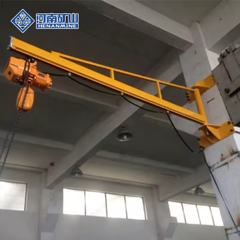 Wall-mounted jib crane fixed to a workshop column with an electric hoist on the arm