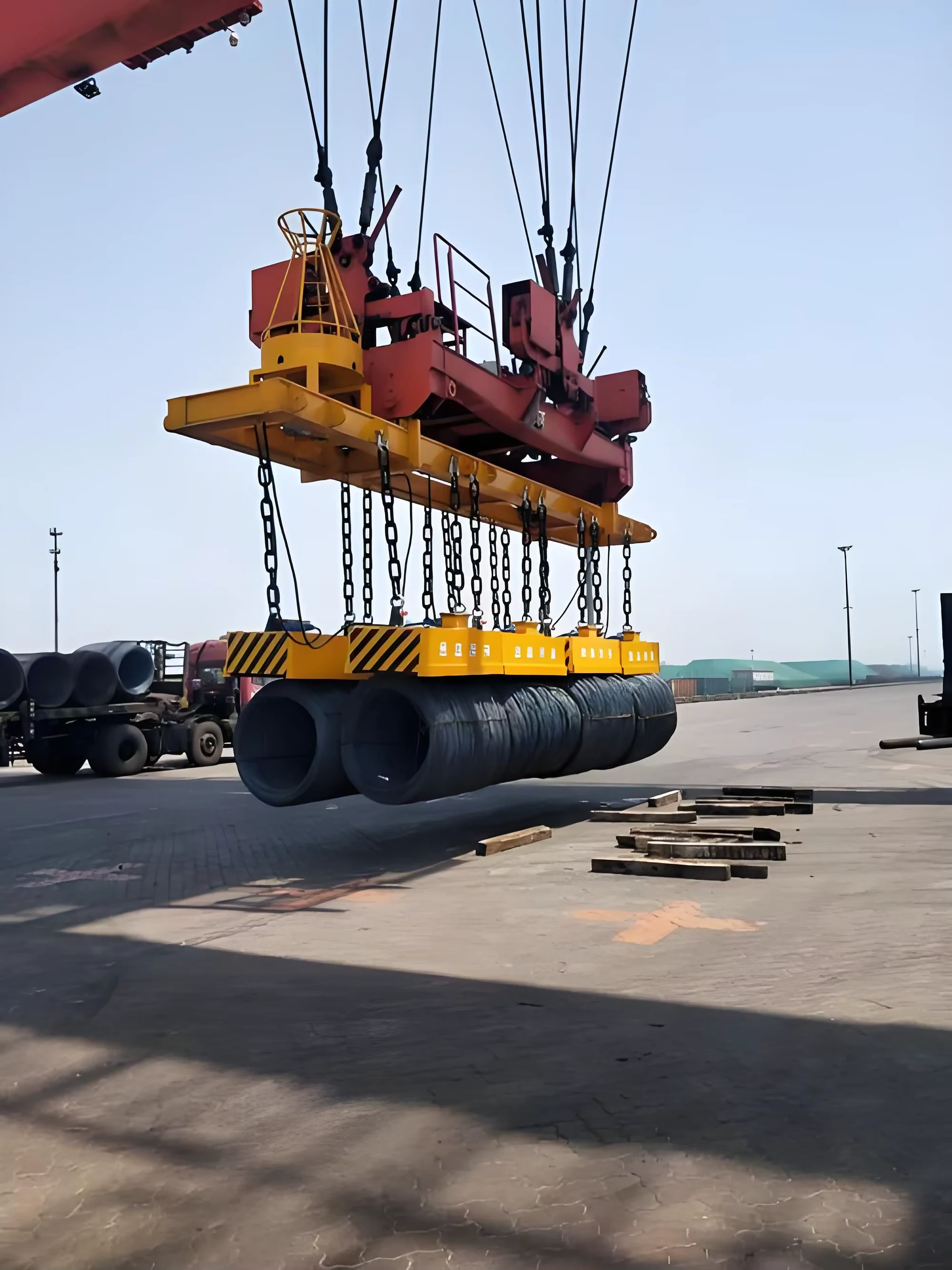 Magnetic lifting beam handling a steel load outdoors