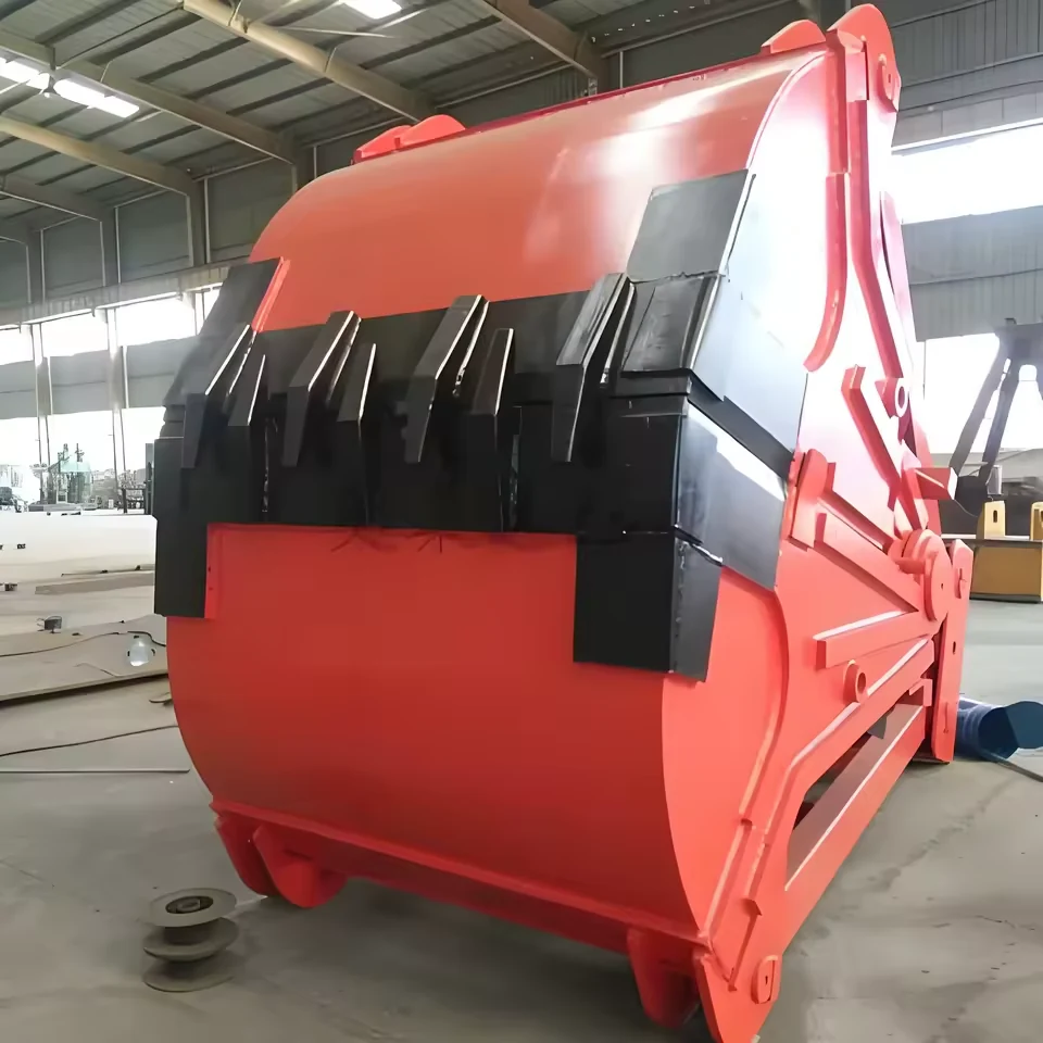 Red and black clamshell grab bucket photographed in a factory