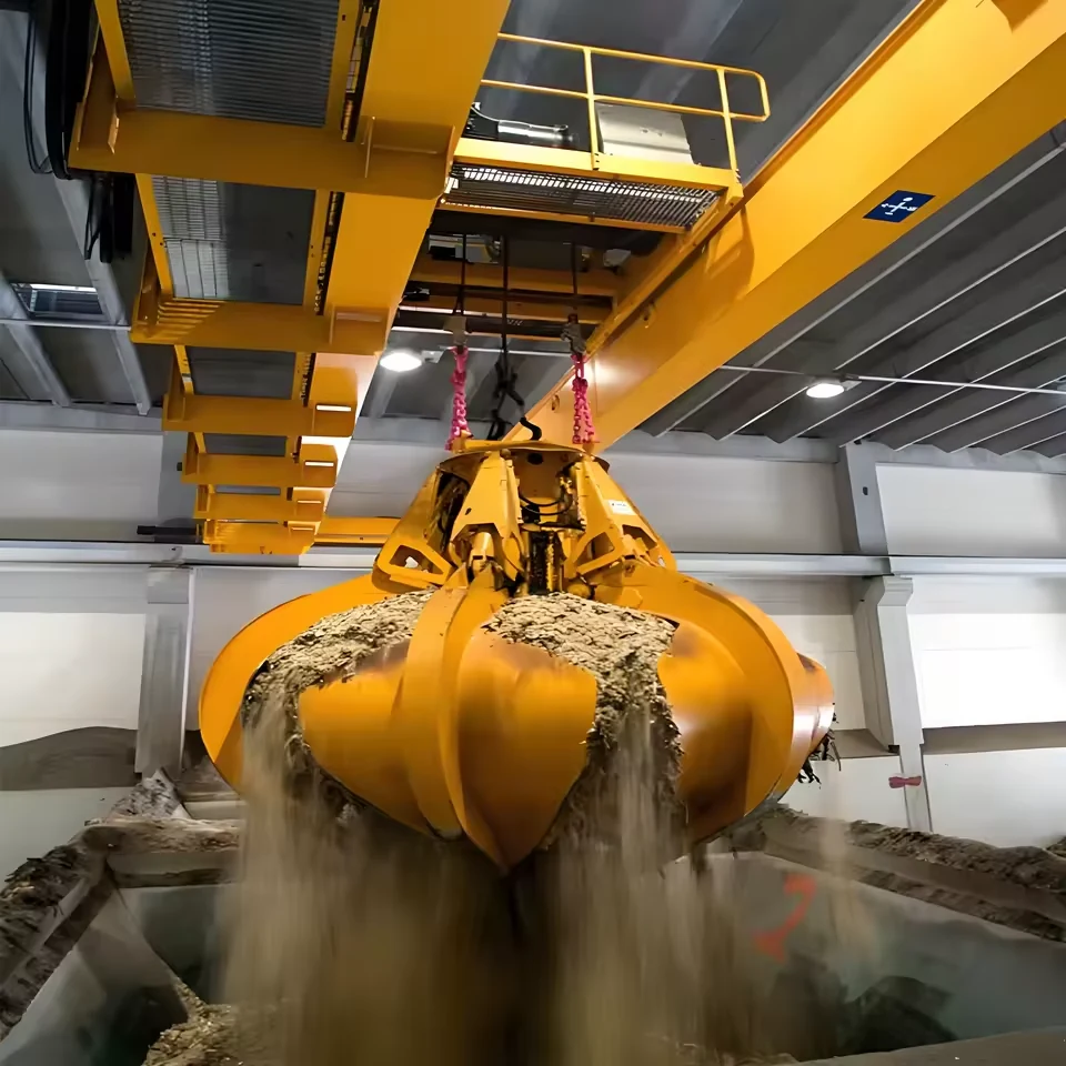 Orange multi-petal grab handling loose material inside an industrial bay