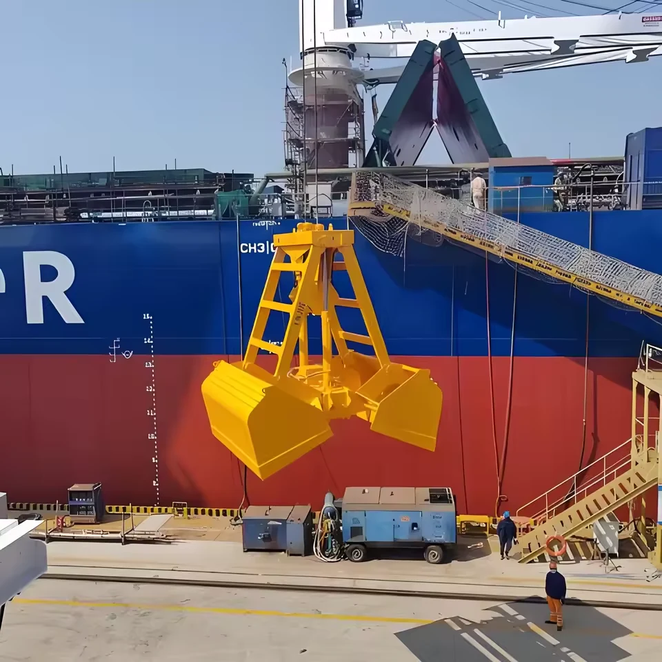 Yellow clamshell grab photographed in a port handling area