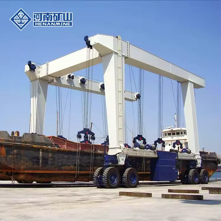 Large white rubber-tyred marine travel lift carrying a vessel in multiple slings at a shipyard