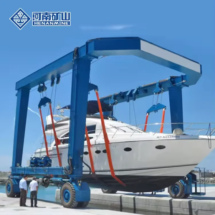 Blue marine travel lift carrying a white yacht on a paved waterfront