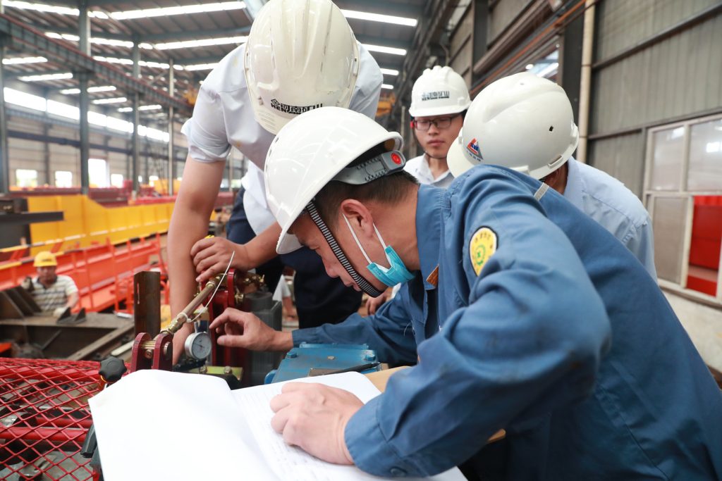 Inspectors checking a crane component and inspection records