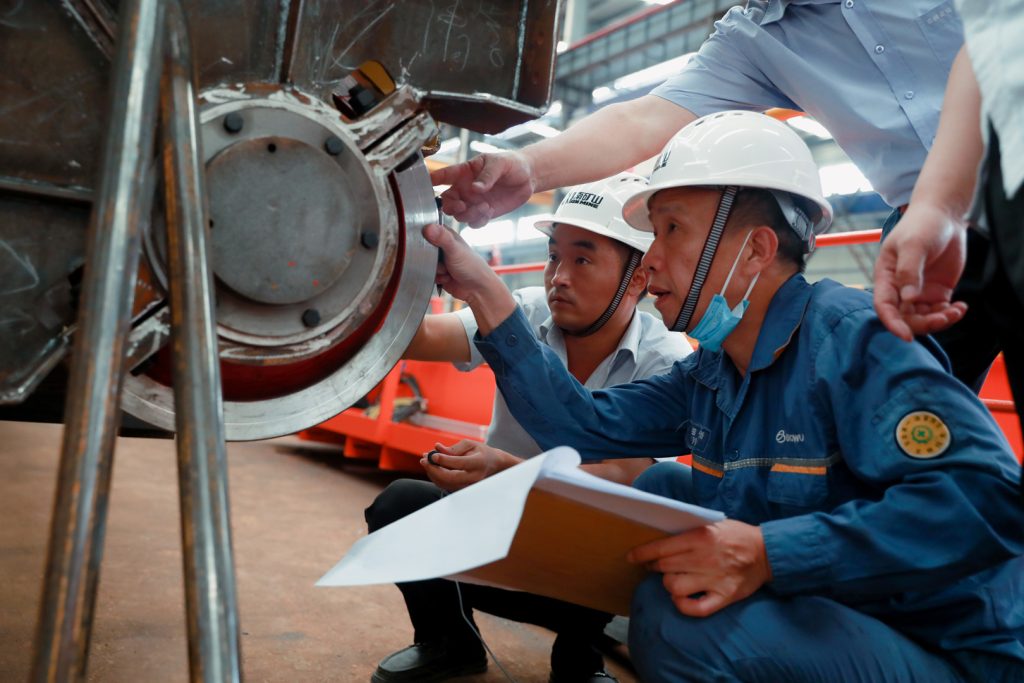 Inspectors measuring a crane wheel and drive assembly
