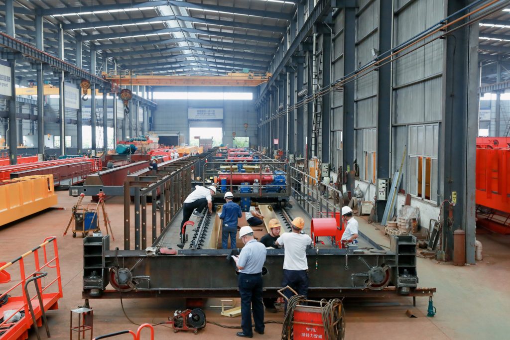Crane equipment and inspection personnel in a manufacturing workshop